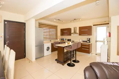a large kitchen with a table and a refrigerator at Villa Athena in Protaras