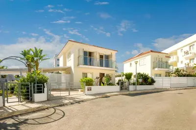 a row of white houses with trees in a street at Villa Athena in Protaras