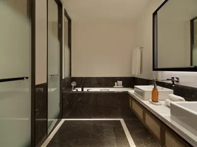 a bathroom with two sinks and a glass shower at City of Dreams Mediterranean - Integrated Resort, Casino & Entertainment in Limassol