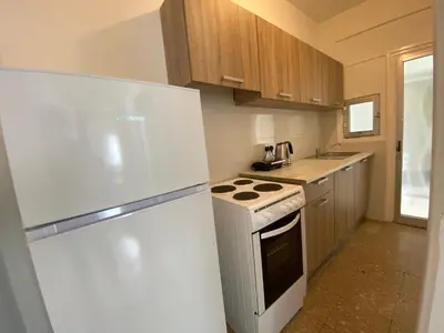 a kitchen with a white refrigerator and a stove at Boho-Chic one bedroom flat in Engomi in Engomi