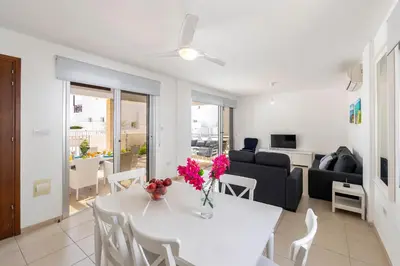 a living room with a white table with flowers on it at Protaras Sapphire Seaside Villa in Protaras