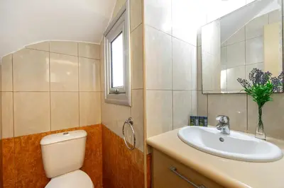 a bathroom with a toilet and a sink and a mirror at Protaras Sapphire Seaside Villa in Protaras