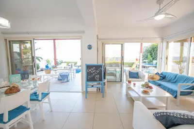 a living room with tables and chairs and a chalkboard at Protaras Artisan Seafront Villa in Protaras