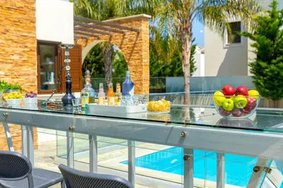 a table with fruit and drinks on top of a swimming pool at Ayia Napa Ionion Seaside Villa in Ayia Napa