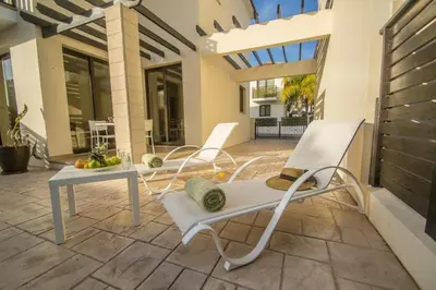 a patio with two chairs and a table with a hat at Protaras Allium Villa in Protaras