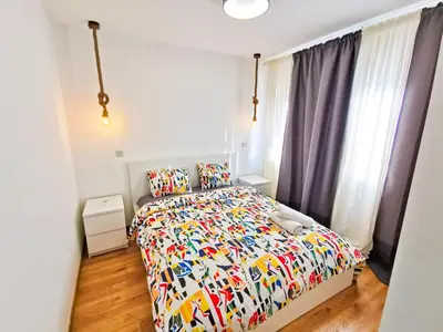 a bedroom with a bed with a colorful comforter at CityCenter Boutique Apartment in Larnaka