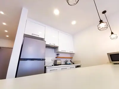 a kitchen with white cabinets and a refrigerator at CityCenter Boutique Apartment in Larnaka