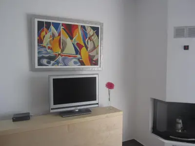 a television on a dresser with a painting on the wall at Marina Apartments 211 in Larnaka