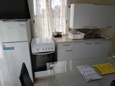 a kitchen with a white refrigerator and a sink at MERSINERA Paradise Garden NOAH HOUSE in Kivisil