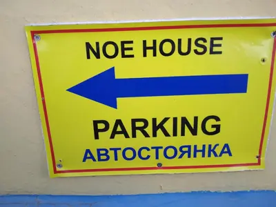 a yellow sign with an arrow on a wall at MERSINERA Paradise Garden NOAH HOUSE in Kivisil