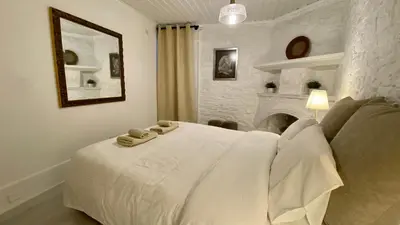 a bedroom with a white bed and a fireplace at Leonys House by TrulyCyprus in Doros