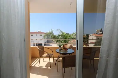a room with a table and chairs and a balcony at NISSI 3 VIEW HOLIDAY 2 BEDROOM APARTMENT in Ayia Napa
