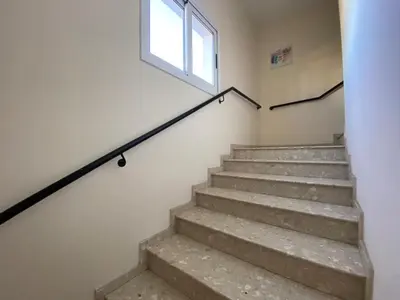 a staircase in a building with a window at NISSI 3 VIEW HOLIDAY 2 BEDROOM APARTMENT in Ayia Napa