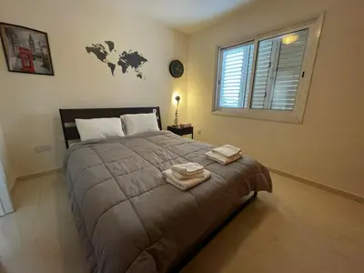 a bedroom with a large bed with two towels on it at 3Bdr in Nicosia in Strovolos