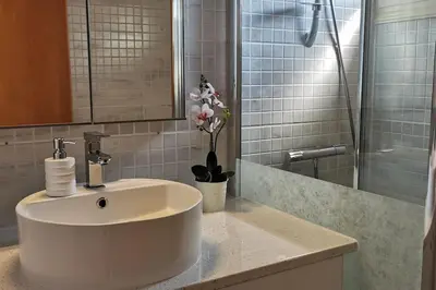 a bathroom with a white sink and a shower at Pretty and quiet studio, with wifi and parking in Limassol