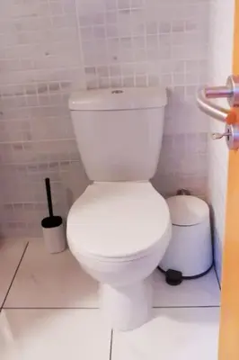 a bathroom with a white toilet and a trash can at Pretty and quiet studio, with wifi and parking in Limassol