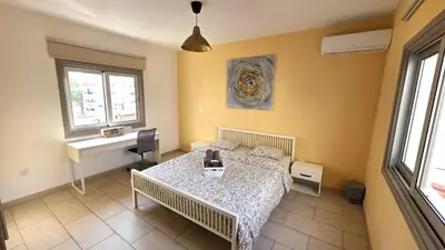 a room with a table and a desk in it at Spacious Lightflooded 2BR Apt / Near Center & Harbour in Larnaka