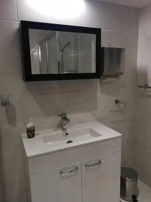 a bathroom with a white sink and a mirror at KALIDONIA RESIDENCE Suite Nicosia , Spacious 2 BR suite with office in Nicosia