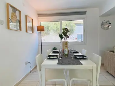 a dining room with a white table and chairs at Serena's 2-BR Apartment in Larnaca in Larnaka
