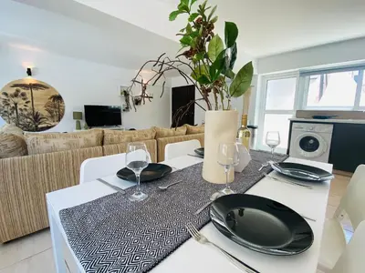 a dining room with a table with plates and glasses at Serena's 2-BR Apartment in Larnaca in Larnaka