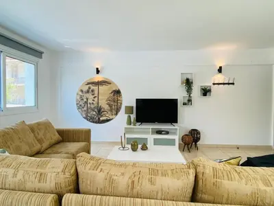 a living room with a couch and a tv at Serena's 2-BR Apartment in Larnaca in Larnaka