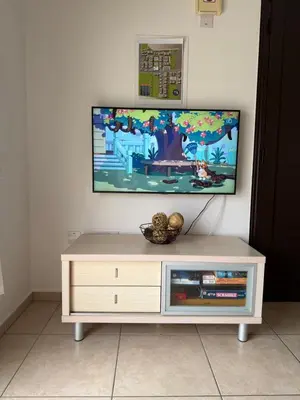 a tv sitting on top of a white entertainment center at Mythical Sands Resort & Spa, Evilion Apartment in Paralimni