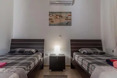 two beds sitting next to each other in a room at Mythical Sands Resort & Spa, Evilion Apartment in Paralimni