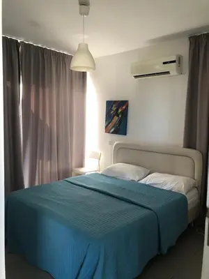 a bedroom with a bed with a blue blanket at Sunny holiday by konnos in Paralimni