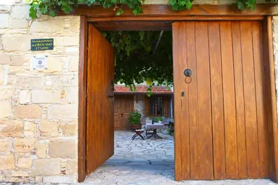 a wooden door on a stone building with a patio at Agrovino Lofou in Lofou