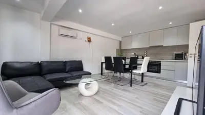 a living room with a black couch and a table at Nagia’s Apartment in Kakopetria