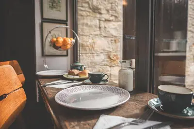 a wooden table with plates and cups on it at Oinoessa Traditional Boutique Guest Houses in Lofou
