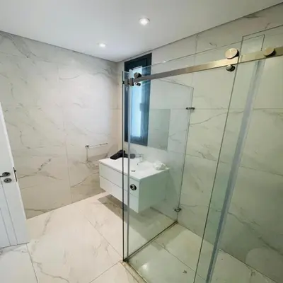 a bathroom with a glass shower and a sink at By the Beach Villa Natalya in Protaras