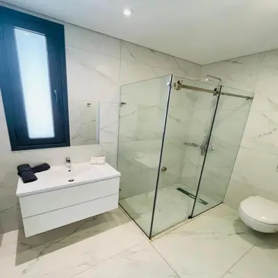 a bathroom with a shower and a sink and a toilet at By the Beach Villa Natalya in Protaras
