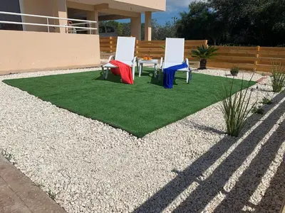 two chairs and a table on a patch of grass at Nissi3 B1 Lovely 1Bdr Ground Floor Apartment near Nissi Beach. in Ayia Napa