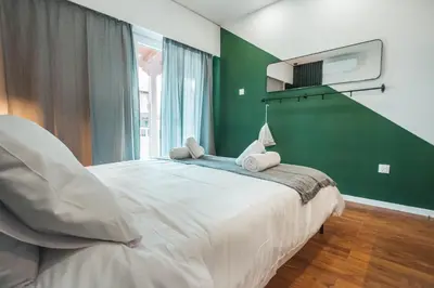 a bedroom with a large bed with a green wall at The Green Apartment in Larnaka