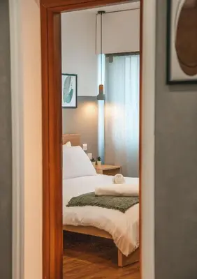 a mirror reflection of a bedroom with a bed at The Green Apartment in Larnaka