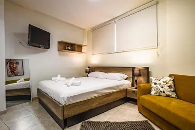 a bedroom with a bed and a couch and a tv at Appartments in the historic center near beach in Limassol