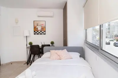 a bedroom with a bed and a desk and a window at Appartments in the historic center near beach in Limassol