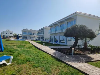 a building with a tree in front of it at Ocean Suites Luxury Apartments in Protaras