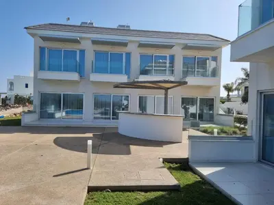 a large building with an umbrella in front of it at Ocean Suites Luxury Apartments in Protaras