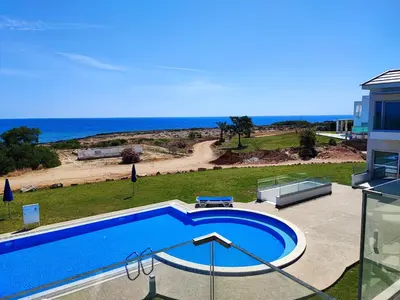 a swimming pool with a view of the beach at Ocean Suites Luxury Apartments in Protaras