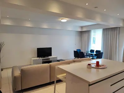 a living room with a couch and a flat screen tv at Ocean Suites Luxury Apartments in Protaras