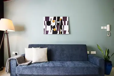 a blue couch in a living room with a painting on the wall at Phaedrus Living City View Luxury Flat Harbour 04 in Larnaka