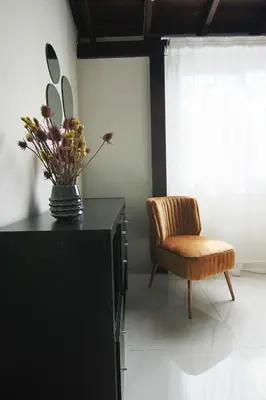 a vase of flowers on top of a black cabinet with a chair at Phaedrus Living City View Luxury Flat Harbour 04 in Larnaka