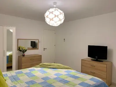 a bedroom with a bed and a television and a pendant light at Villa Kapparis Sunrise in Paralimni