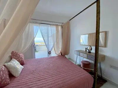 a bedroom with a bed and a desk and a window at Villa Kapparis Sunrise in Paralimni