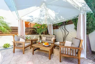 a patio with chairs and tables under a tent at Protaras Villa Athamas Blue in Protaras
