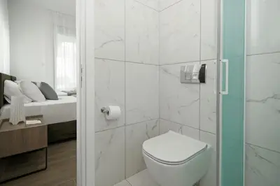 a white bathroom with a toilet and a sink at Villa Queen Valeria in Protaras