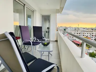 a balcony with chairs and a table on a building at Panoramic Seaside Getaway, 2-BR Penthouse in Larnaka