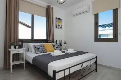 a bedroom with a large bed in a room with windows at Villa Levandini in Protaras